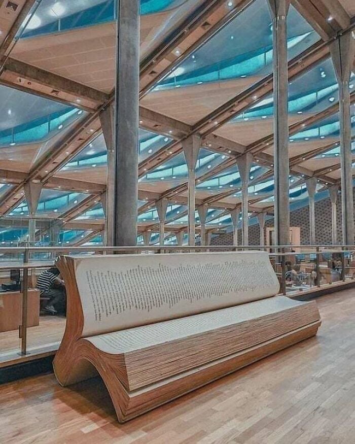 Banco con forma de libro abierto dentro de una biblioteca moderna y grandiosa con arquitectura de vidrio y metal de todo el mundo.
