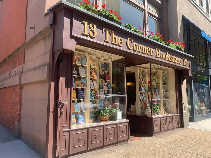 Exterior de una librería encantadora con jardineras, mostrando una librería acogedora y mágica de todo el mundo.
