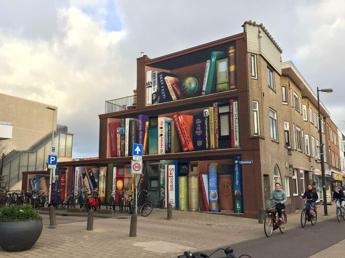 Building facade painted with giant, colourful books, creating a magical library and bookstore atmosphere in an urban setting. Building facade painted with giant, colourful books, creating a magical library and bookstore atmosphere in an urban setting.